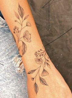 a woman's foot with a flower tattoo on the left side of her arm