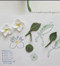 crocheted flowers and leaves are displayed on a white sheet with writing underneath them