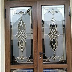 two glass doors with decorative designs on the front and side panels, one is brown