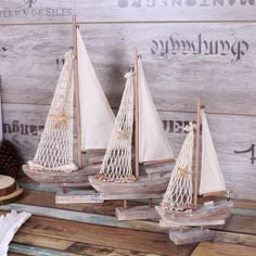 three small sailboats are sitting on a table