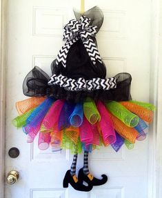 a door hanger decorated with colorful tutues and a black cat on it