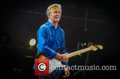 a man with glasses playing an electric guitar