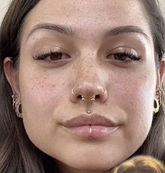 a close up of a woman with piercings on her nose