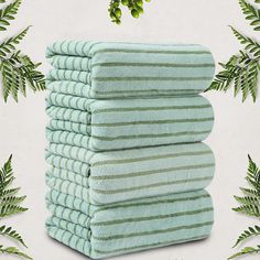 six towels stacked on top of each other in front of green plants and foliages