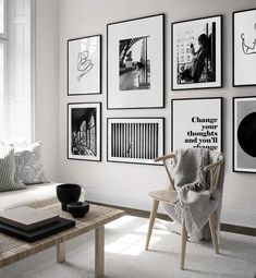 a living room with white walls and pictures on the wall, coffee table and chair