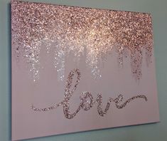 the word love is written in glitter on a pink background