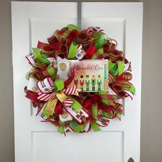 a christmas wreath on the front door decorated with ribbons and books for children to read