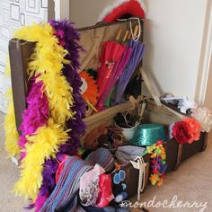 an open suitcase filled with lots of colorful items next to a white wall and door