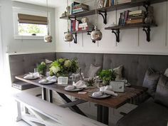 the table is set with place settings for two people to sit at, and there are bookshelves on the wall behind it