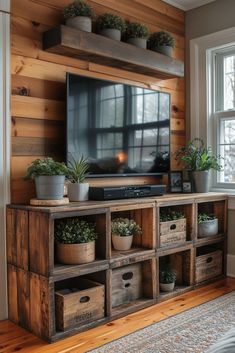 an entertainment center made out of wooden crates with plants on top