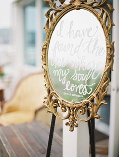 a mirror with writing on it sitting on top of a wooden table