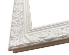 an ornate white frame is shown against a white background, with the edge painted off