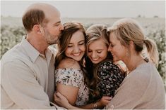 a group of people hugging each other in front of a field