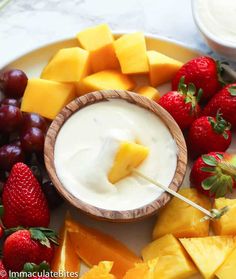 fruit platter with cheese, strawberries and grapes on the side for dipping sauce