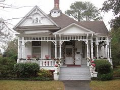 a white house with flowers on the front porch