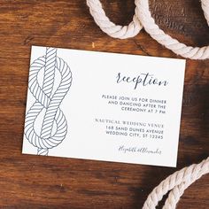 a white business card on top of a wooden table next to twine and rope