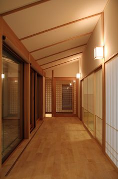 an empty room with wooden flooring and sliding glass doors leading to the second floor