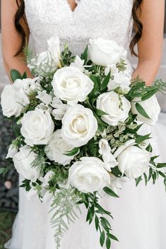 a bride holding a bouquet of white flowers