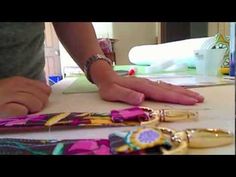 a person standing at a table with several bracelets on it