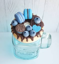 a cupcake decorated with blue and brown icing on top of a glass jar