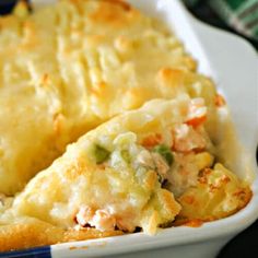 a casserole dish with chicken and vegetables in it on a blue and white plate