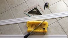 a pair of scissors laying on the floor next to a yellow basket with holes in it