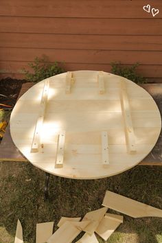 a table made out of wood sitting on top of grass