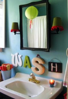 a bathroom sink sitting under a mirror in front of a wall mounted light above it