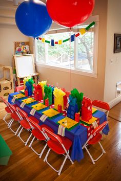 a birthday party table with balloons and gifts on it for the kids to eat at