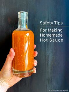 a hand holding a bottle of hot sauce with the words safety tips for making homemade hot sauce