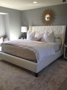 a bedroom with a large bed and two lamps on either side of the headboard