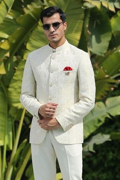 a man wearing a white suit and sunglasses