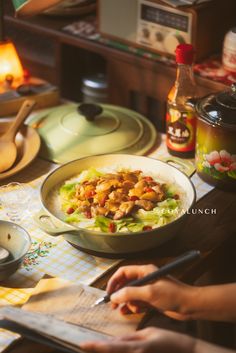 a person is preparing food in a pan on the table with other dishes and utensils