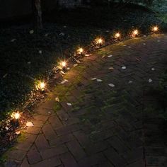 some lights that are on the side of a brick path