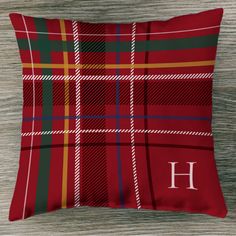 a red plaid pillow with the letter h on it