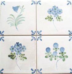 four blue and green flowers on white tiles