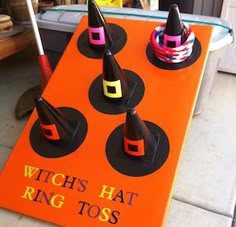 a witches hat ring toss game sitting on the ground next to a table with candy in it