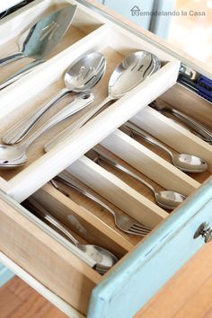 an open drawer with silverware in it