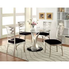 a glass dining table with four chairs and a white rug in front of the window