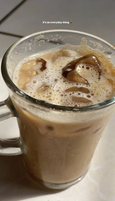 a glass mug filled with liquid on top of a table