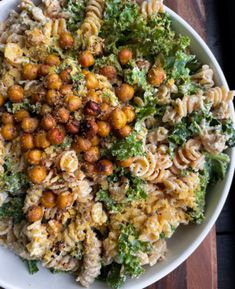 pasta salad with chickpeas and broccoli in a white bowl on a wooden table