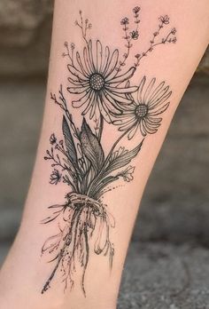 a woman's foot with flowers and leaves on the bottom part of her leg