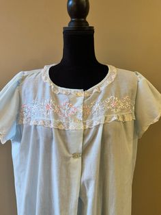 A lightweight nightgown, perfect for the warmer months.  The nightgown is light blue with lace trim on the neckline and sleeves.  the bodice has embroidery of pink, light blue and white.  Three buttons down the front.  In good vintage condition with no rips or stains.  NO tags.  Easy care poly cotton.  The bust measures 24 inches from armpit to armpit laying flat.  39 inches from shoulder to hem.  Please examine the pics, feel free to ask questions. Vintage Nightgown, Light Blue Shorts, Women's Nightgowns, Nightgowns, Pink Light, Blue Shorts, Night Gown, Lace Trim, Bodice