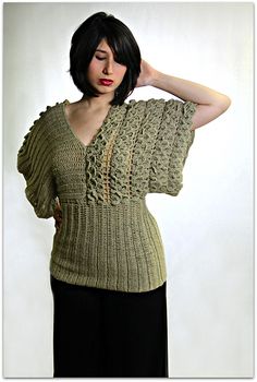 a woman with short black hair wearing a crochet top