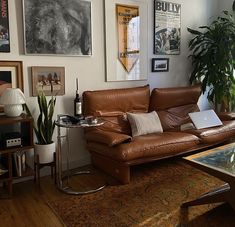 a living room filled with furniture and lots of pictures on the wall above it's coffee table