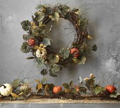 a wreath with pumpkins and leaves on it