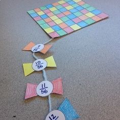 a number line made out of colored paper and some stickers on the ground next to it