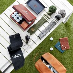 an assortment of personal items are laid out on the grass next to a white bench