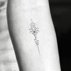 a black and white photo of a flower tattoo on the left inner arm, with an arrow in the middle