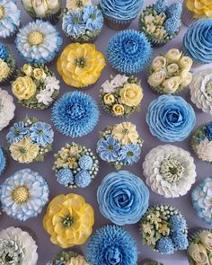 blue and yellow cupcakes with flowers on them are arranged in a square pattern